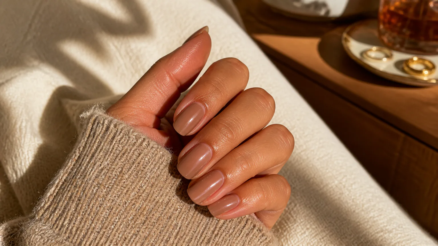 Hand with glossy nude manicured nails