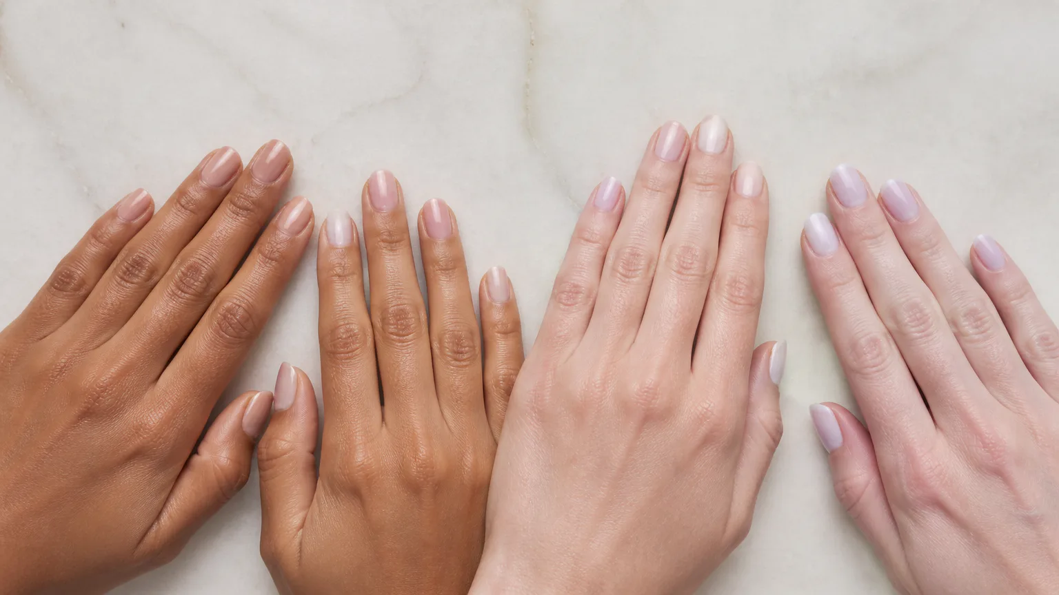 Hands with varied skin tones and nude manicures