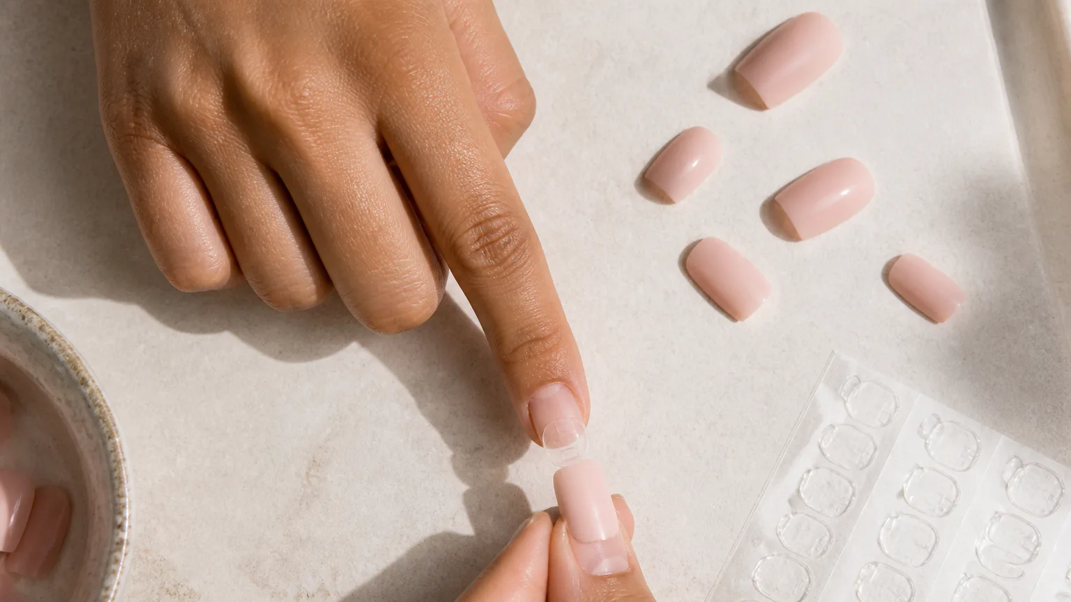 Applying a pink press-on nail